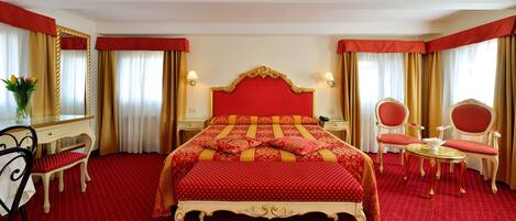 A hotel room with a large bed, two bedside tables, a desk, a chair, and a small table with a mirror.