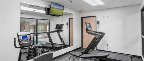 A gym with treadmills, a stationary bike, and a weight bench.