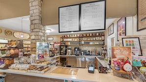 A café with a menu board, coffee machines, and a variety of baked goods on display. - Best Western Vista Inn (Buena Vista)
