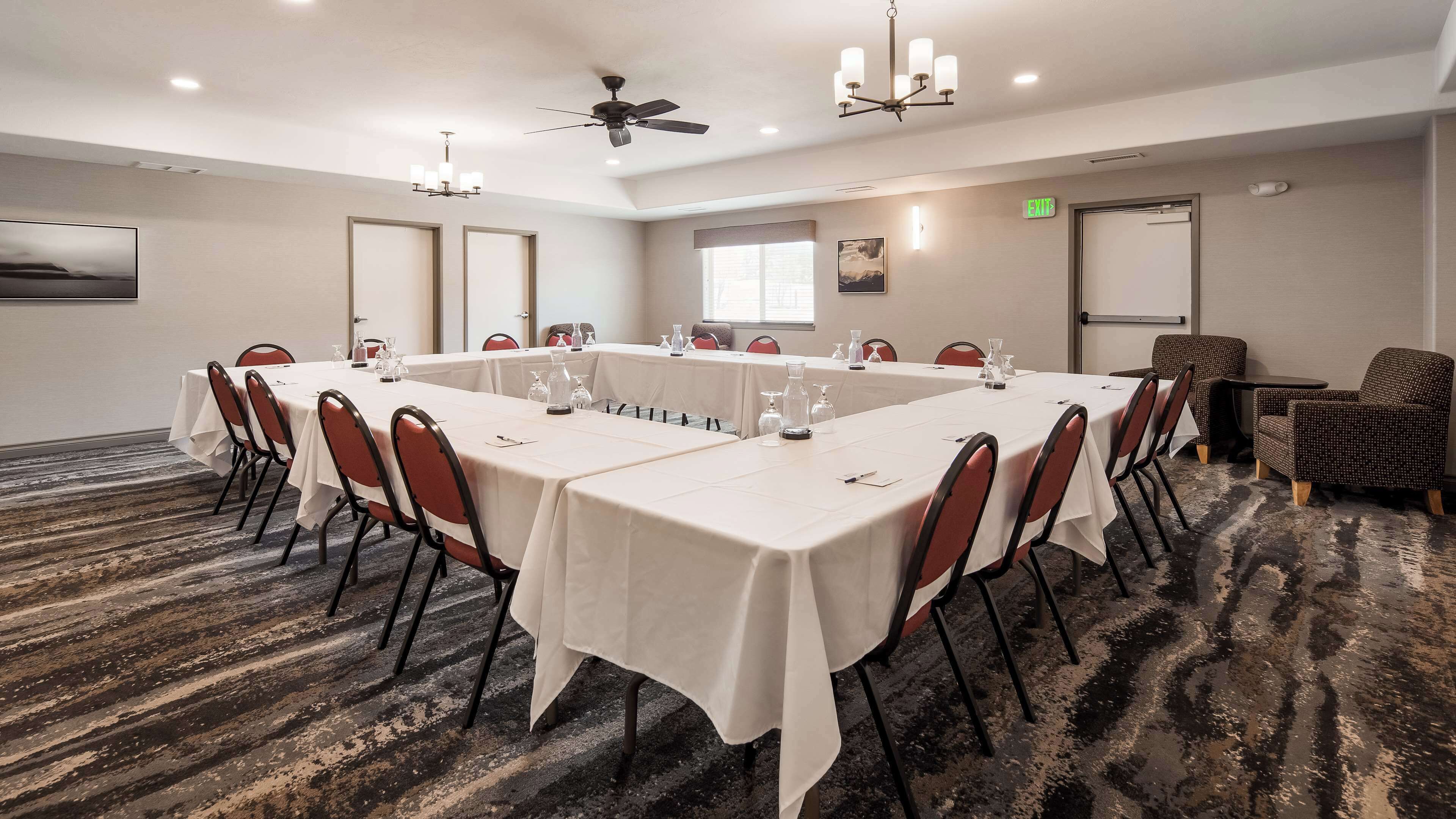A conference room with a long table, chairs, and a chandelier.