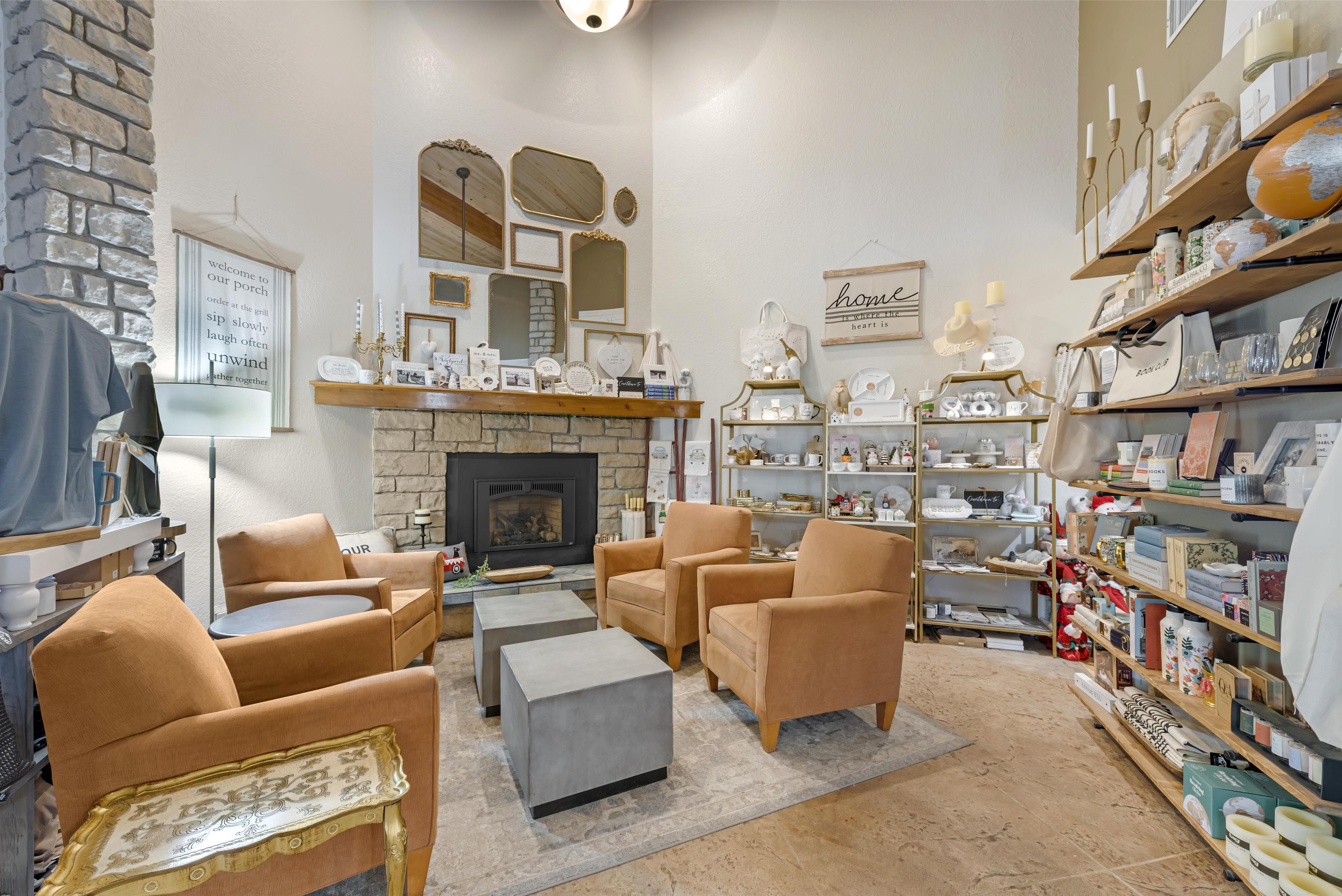 A cozy living room with a fireplace, comfortable seating, and a variety of decorative items on shelves.
