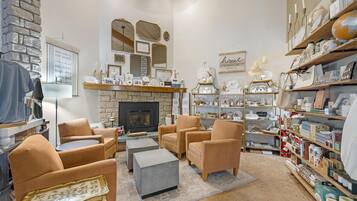 A cozy living room with a fireplace, comfortable seating, and a variety of decorative items on shelves.