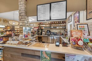 A café with a menu board, coffee machines, and a variety of baked goods on display. - Best Western Vista Inn (Buena Vista)