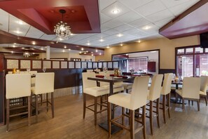 A restaurant with multiple dining tables and chairs, wooden flooring, and a decorative chandelier. - Best Western Grande Prairie Hotel & Suites (Grande Prairie)