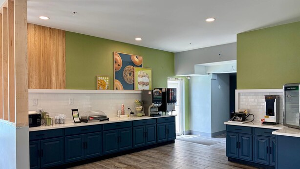 A modern kitchen with dark blue cabinets, a white countertop, and a wooden floor. - Quality Inn & Suites Georgetown - Seaford (Georgetown)
