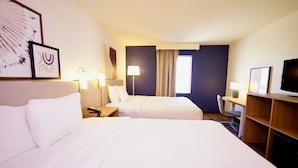 A hotel room with two beds, a desk, a chair, a TV, and artwork on the walls. - Quality Inn & Suites Georgetown - Seaford (Georgetown)