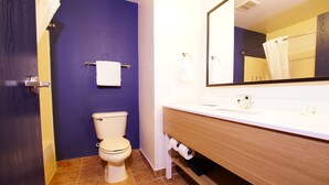 A bathroom with a toilet, sink, mirror, and towel rack. - Quality Inn & Suites Georgetown - Seaford (Georgetown)