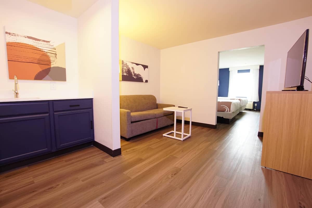 Un salon moderne avec un canapé, une petite table et un plancher en bois.
