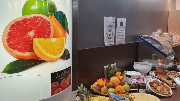 Un buffet de petit-déjeuner proposant une variété de fruits, de viennoiseries et de boissons.