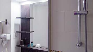 A modern bathroom with a white sink, a mirror, a hairdryer, a showerhead, and a towel rack.