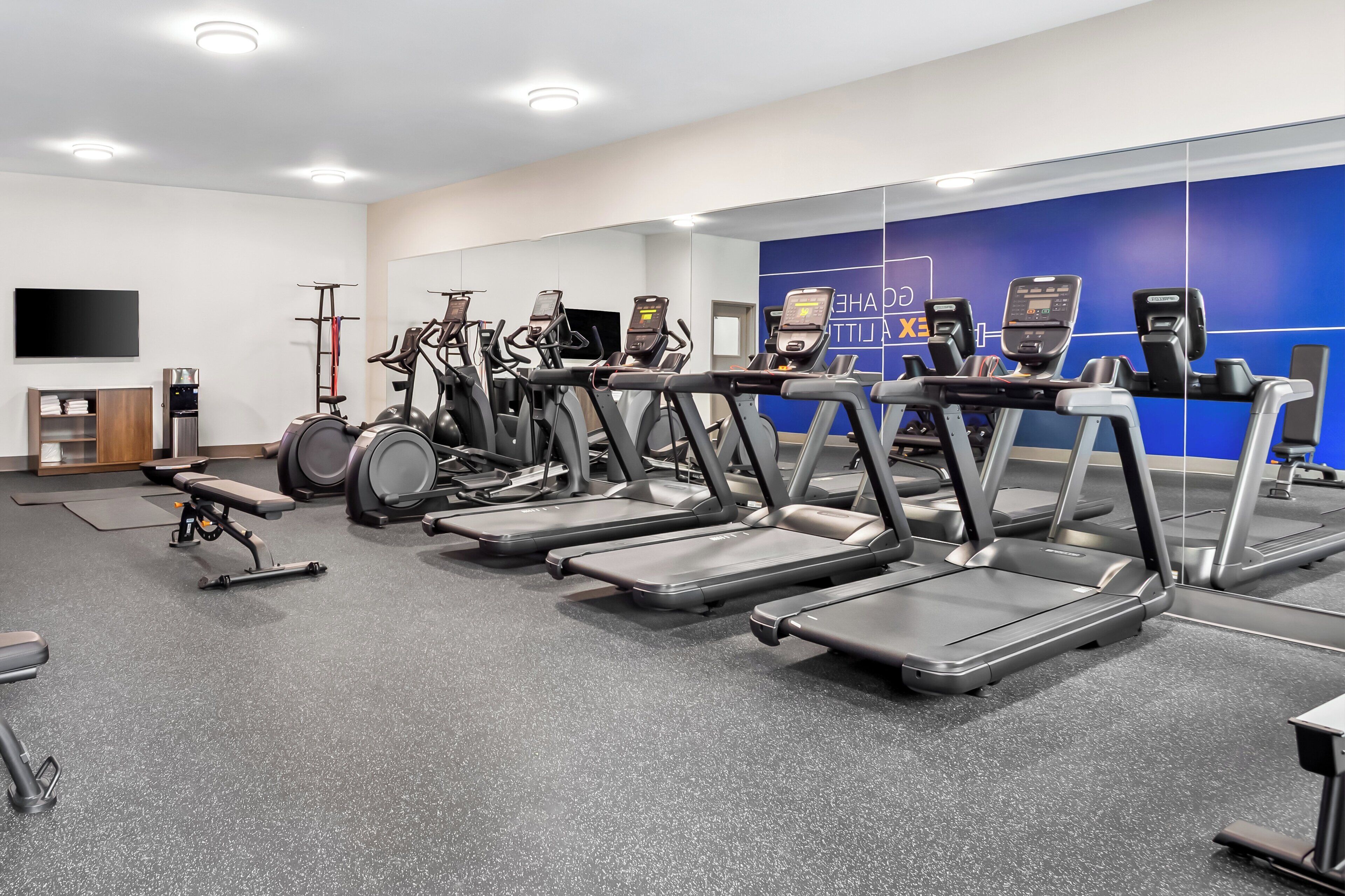 A gym with multiple treadmills, a stationary bike, and a rowing machine.