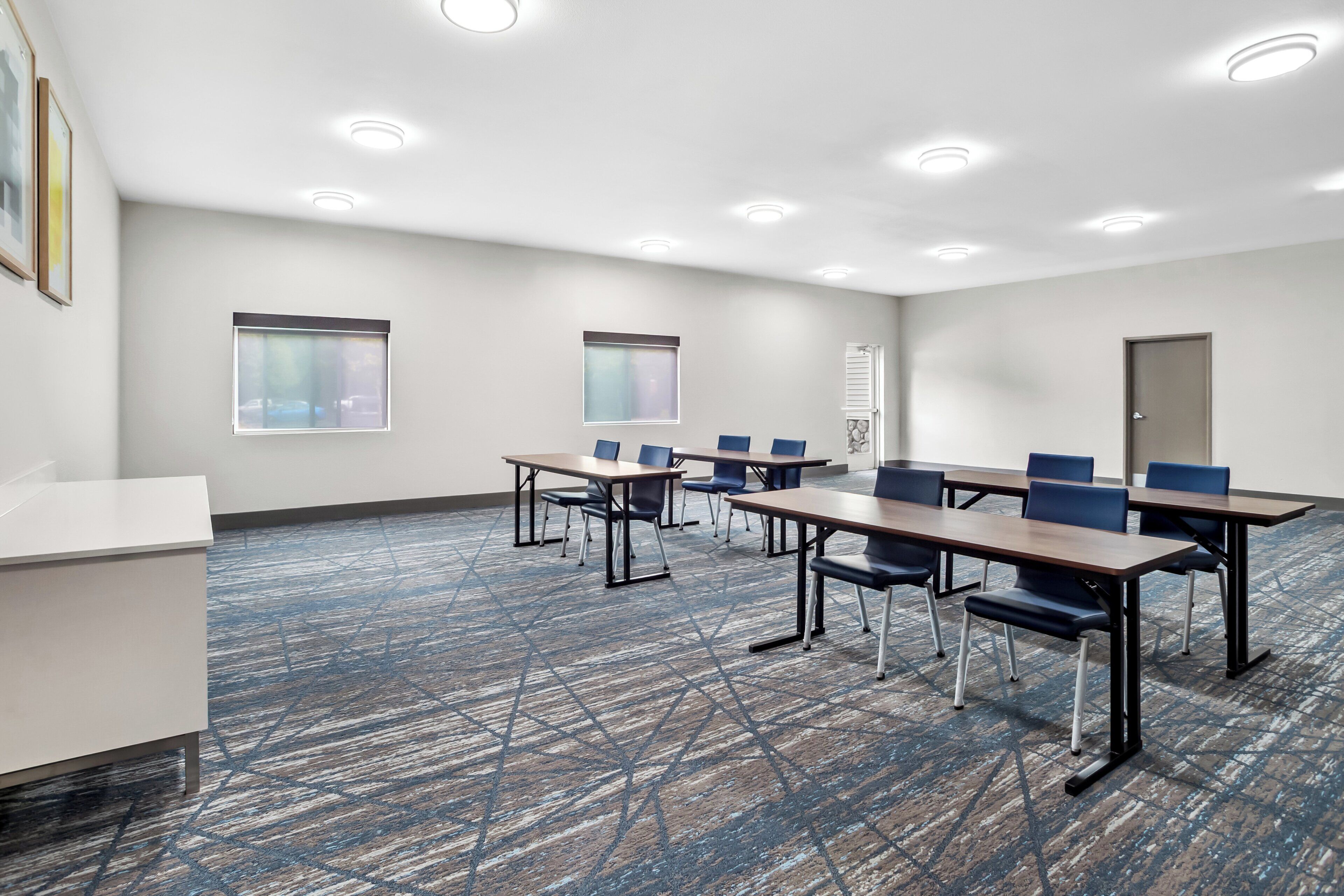 Une salle de conférence avec une longue table, des chaises et un tableau blanc.