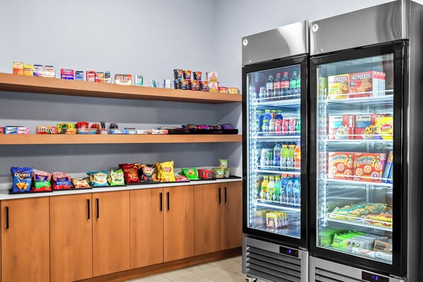 Un espace proposant des distributeurs automatiques de collations et de boissons, avec un assortiment varié de produits.