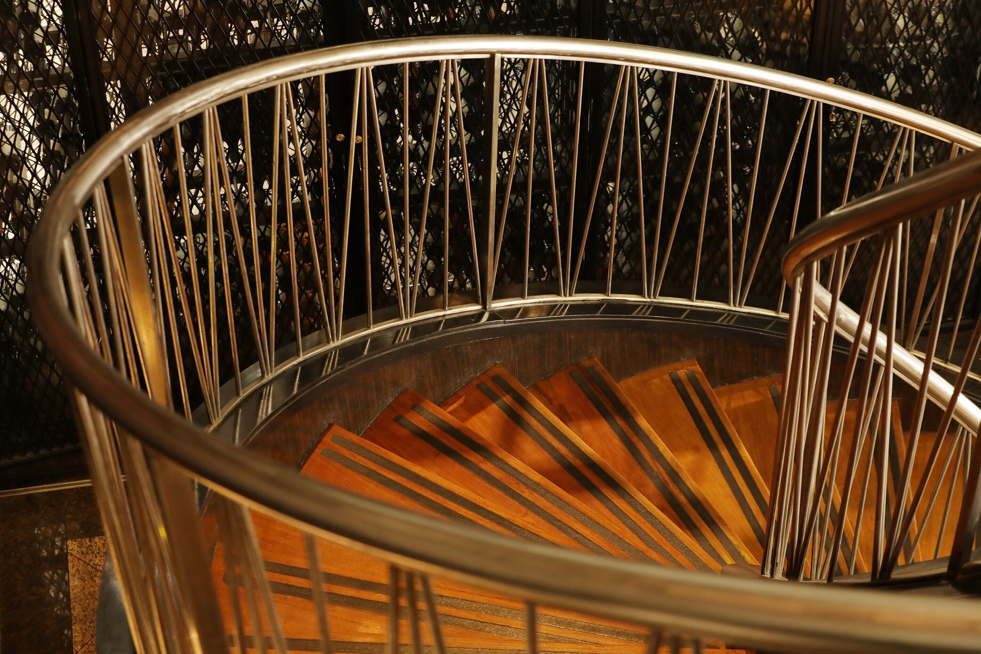A spiral staircase with metal railings and wooden steps.