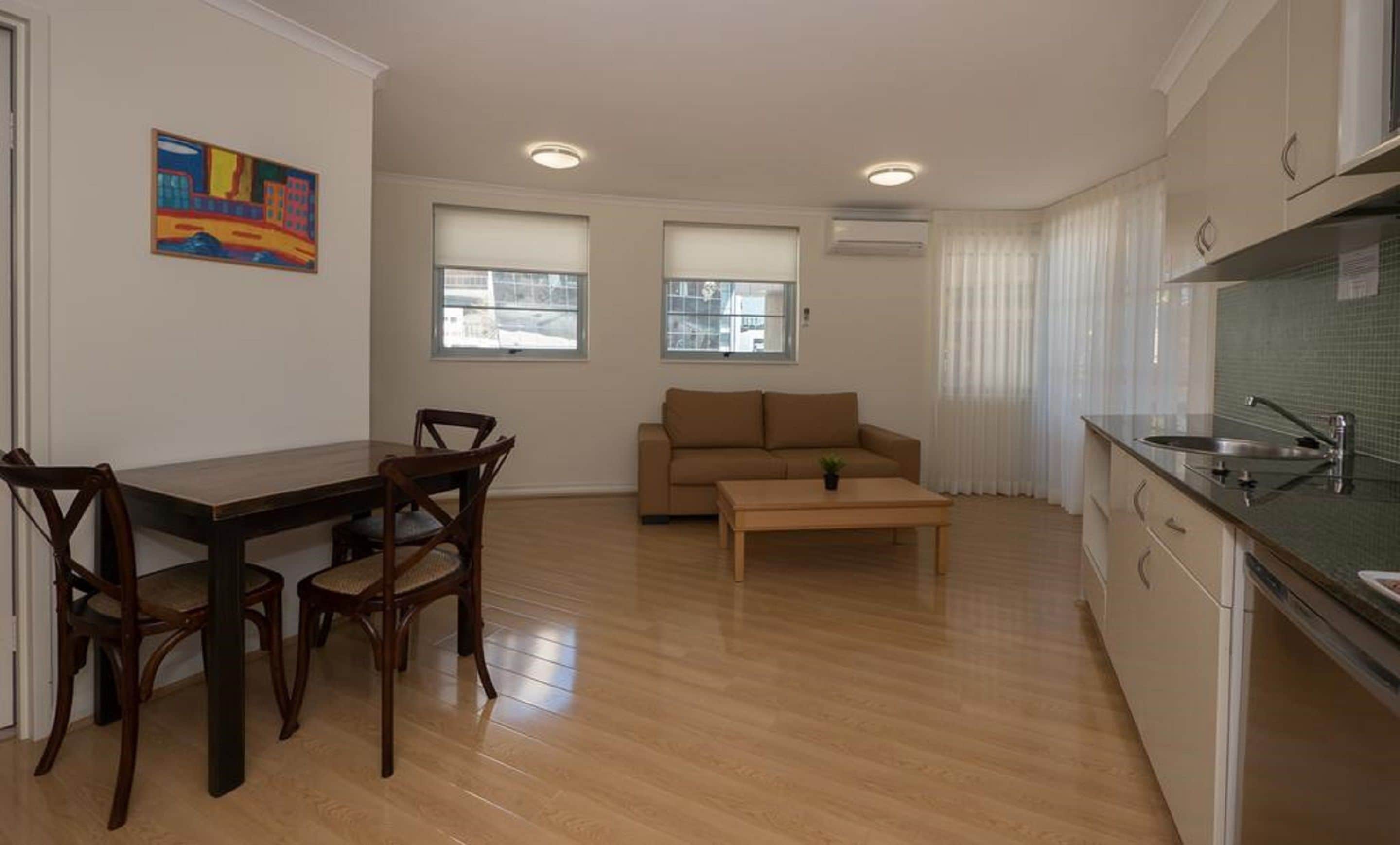 Un espacio habitable compacto con comedor, sofá y kitchenette.