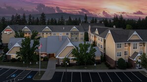 Ett Marriott Residence Inn-hotell med en parkeringsplats, parkeringsplatser anpassade för personer med funktionsnedsättning och en flaggstång med en amerikansk flagga.