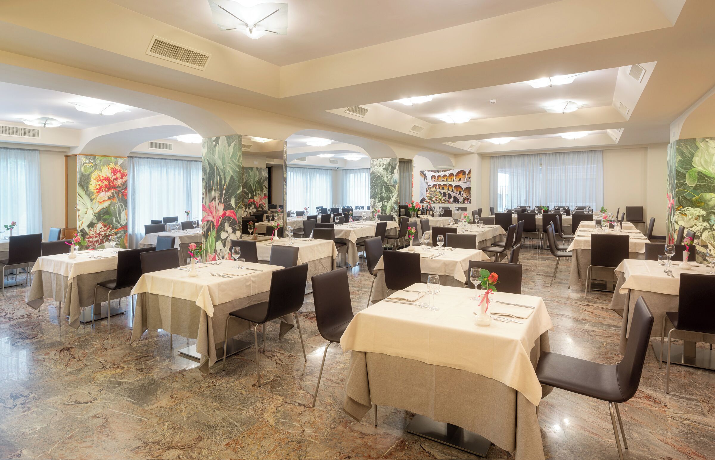 Un grand espace dédié à la salle à manger, avec plusieurs tables et chaises disposées en forme de U.
