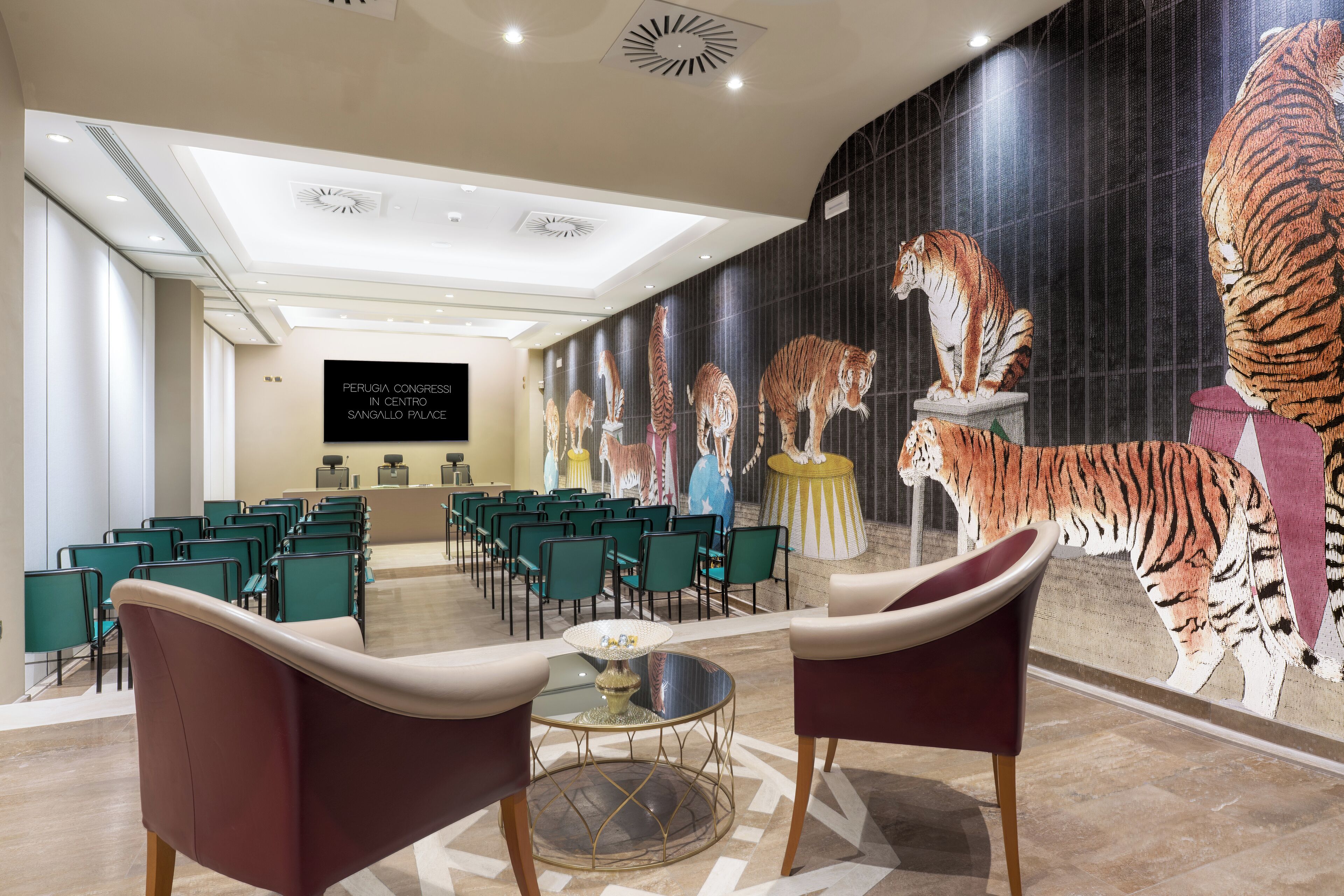 A conference room with green chairs and a large mural of tigers on the wall.