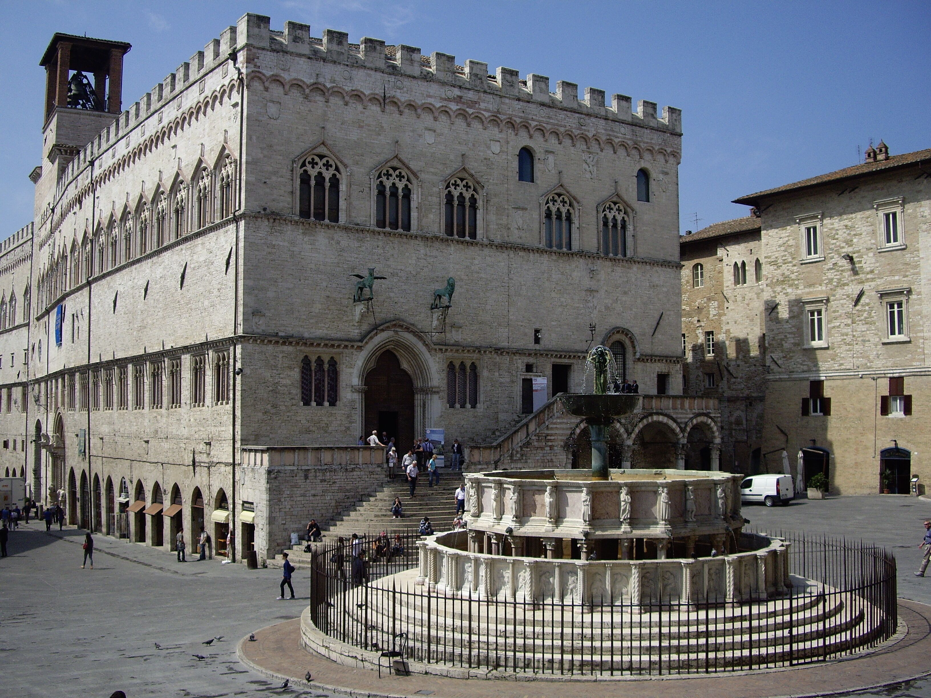 A historic building with a central fountain, arched windows, and a bell tower.