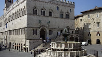 A historic building with a central fountain, arched windows, and a bell tower.