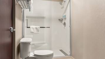 A modern bathroom with a glass-enclosed shower, a toilet, and a towel rack.