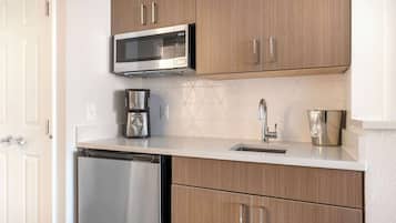 A compact kitchen with a microwave, coffee maker, and dishwasher.