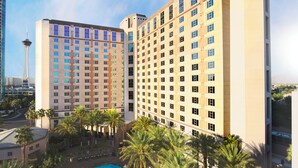 A hotel with multiple high-rise buildings, a swimming pool, and palm trees.