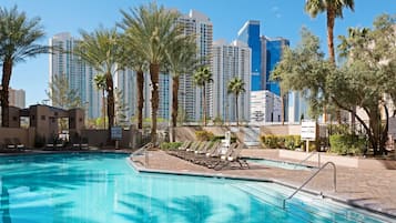 Una piscina al aire libre, sillones reclinables de piscina