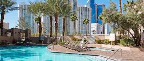 Una piscina al aire libre, sillones reclinables de piscina