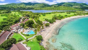 Un complexe hôtelier doté d’une plage, d’une piscine et d’une végétation luxuriante.