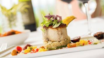 A plated dish with a piece of meat, rice, and vegetables.