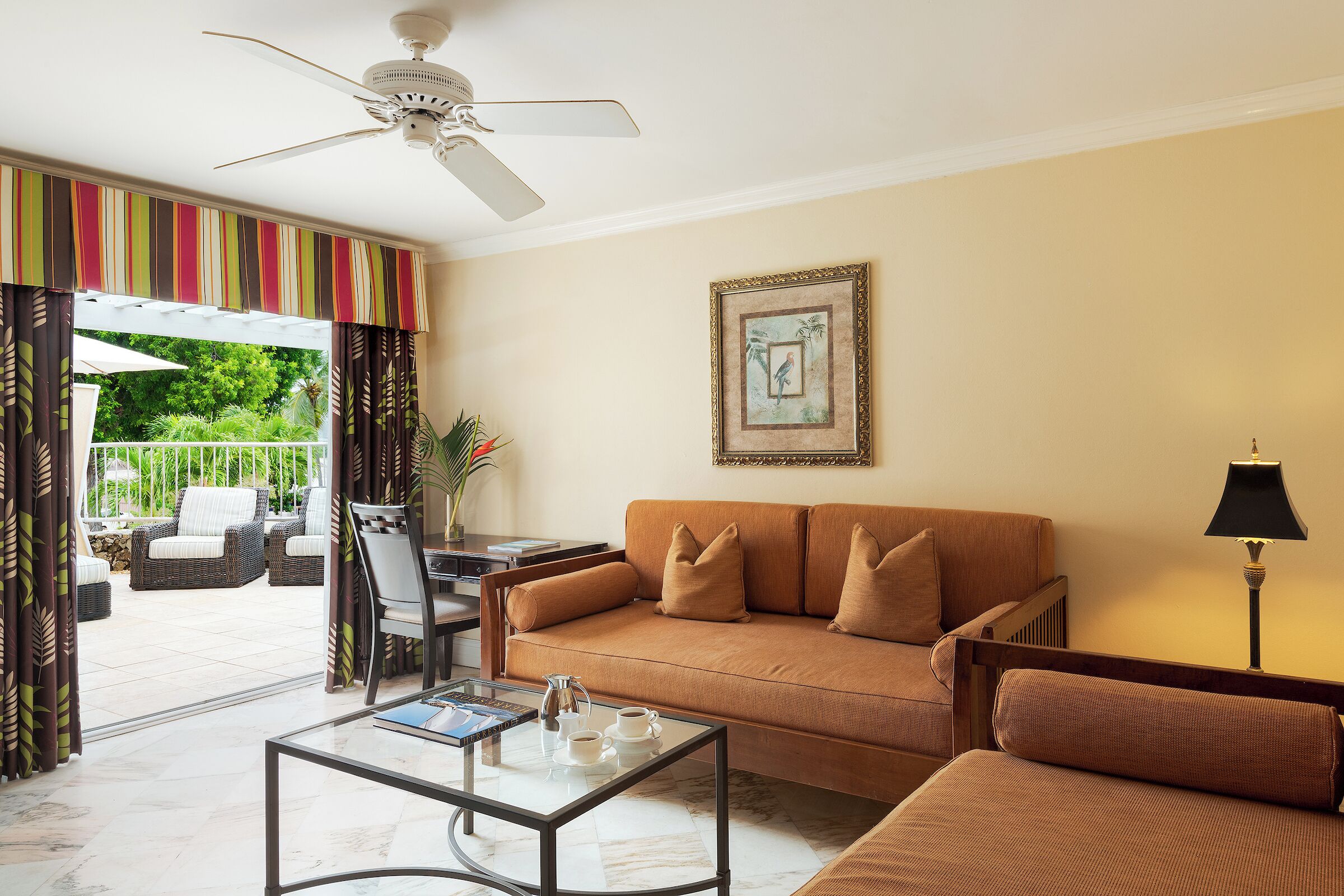 A living room with a sofa, coffee table, and a ceiling fan.