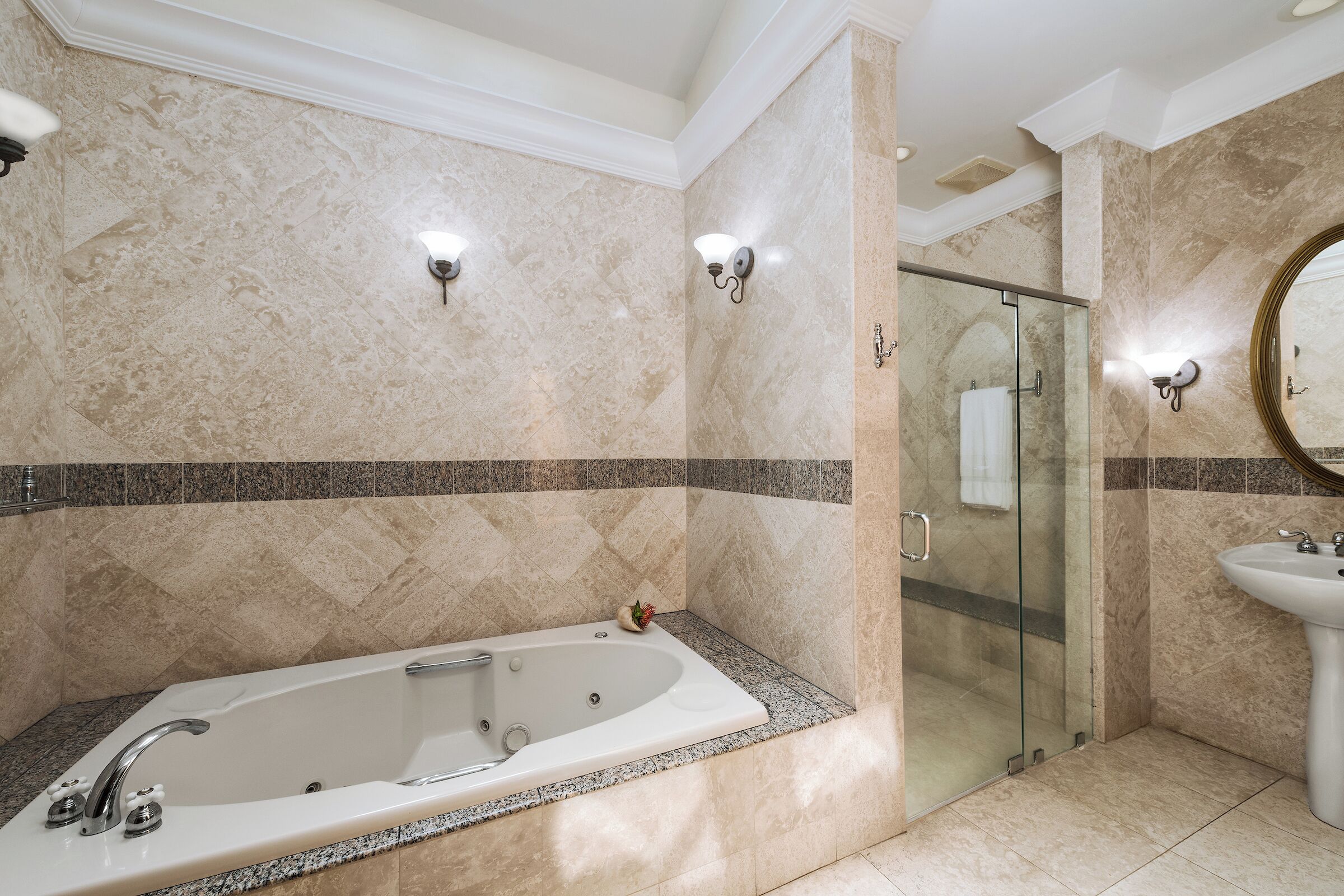 Une salle de bain moderne avec une baignoire sur pieds, une douche à parois de verre et un lavabo sur colonne.