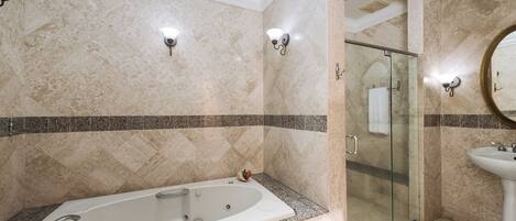 Une salle de bain moderne avec une baignoire sur pieds, une douche à parois de verre et un lavabo sur colonne.