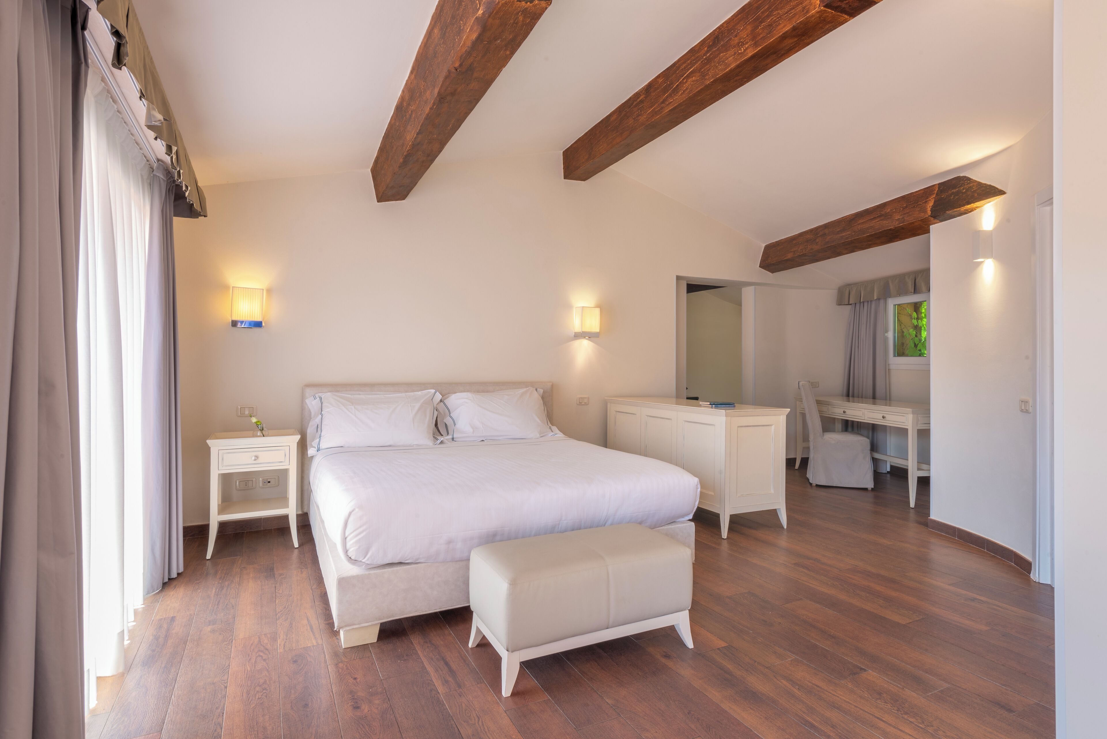 Ein Schlafzimmer mit Bett, Nachttischen, Schreibtisch und Stuhl.