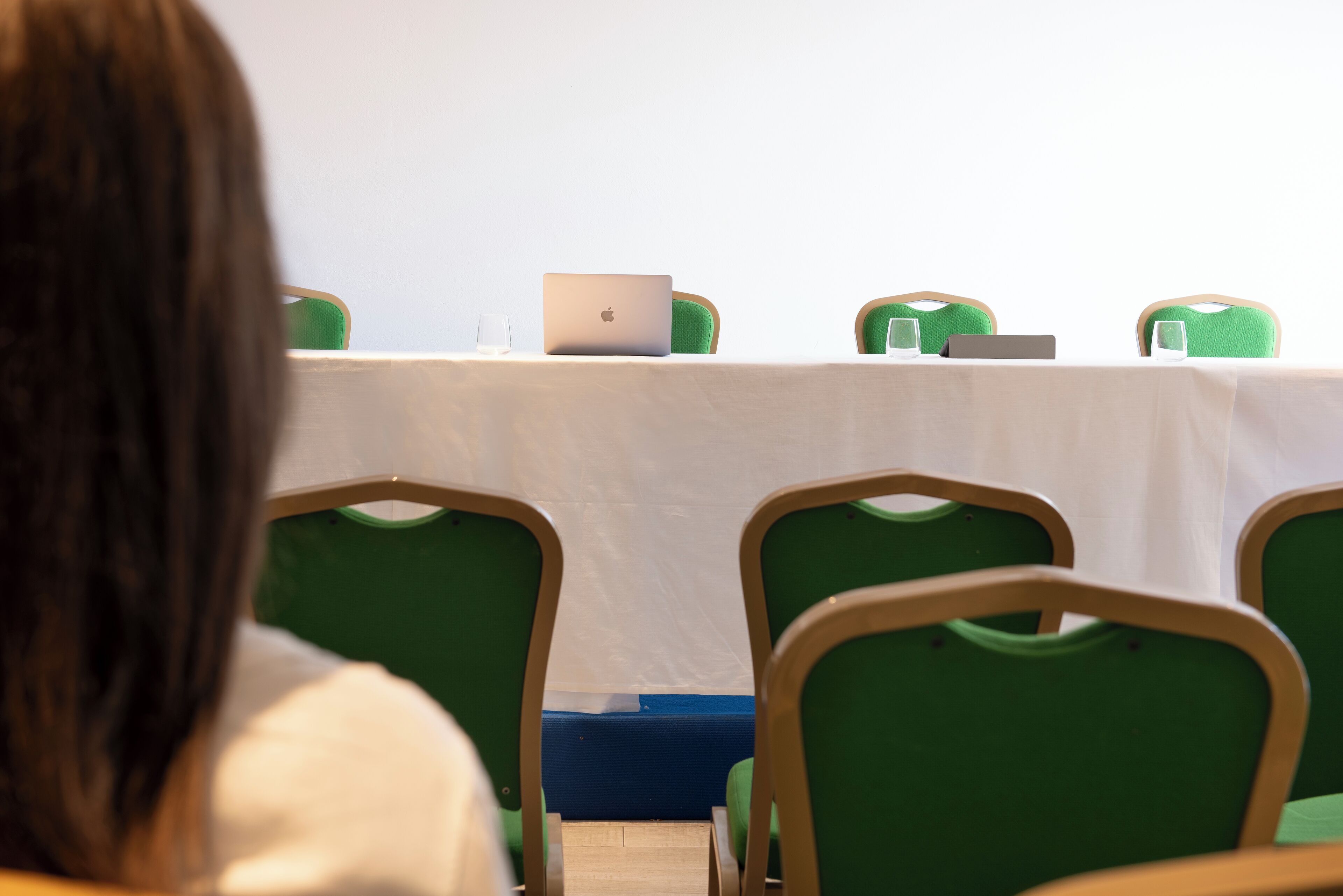 A conference room with a table, chairs, and laptops.