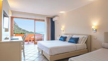 Una habitación de hotel con cama, escritorio y vista al mar.