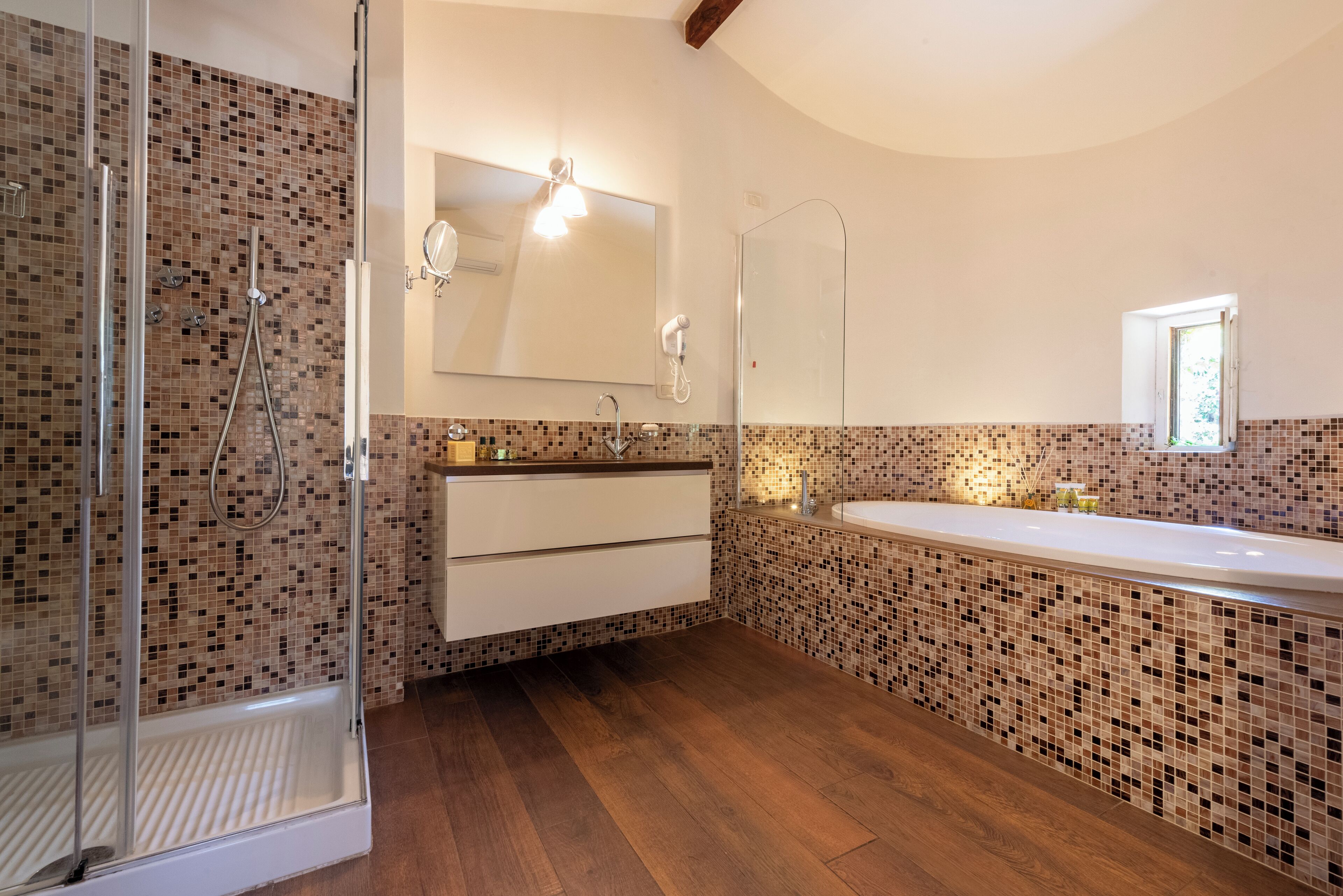 Un baño moderno con ducha, un espejo grande y un tocador con lavabo.