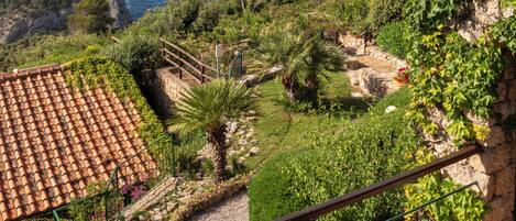 A coastal property with a stone staircase leading to a terrace overlooking the sea.
