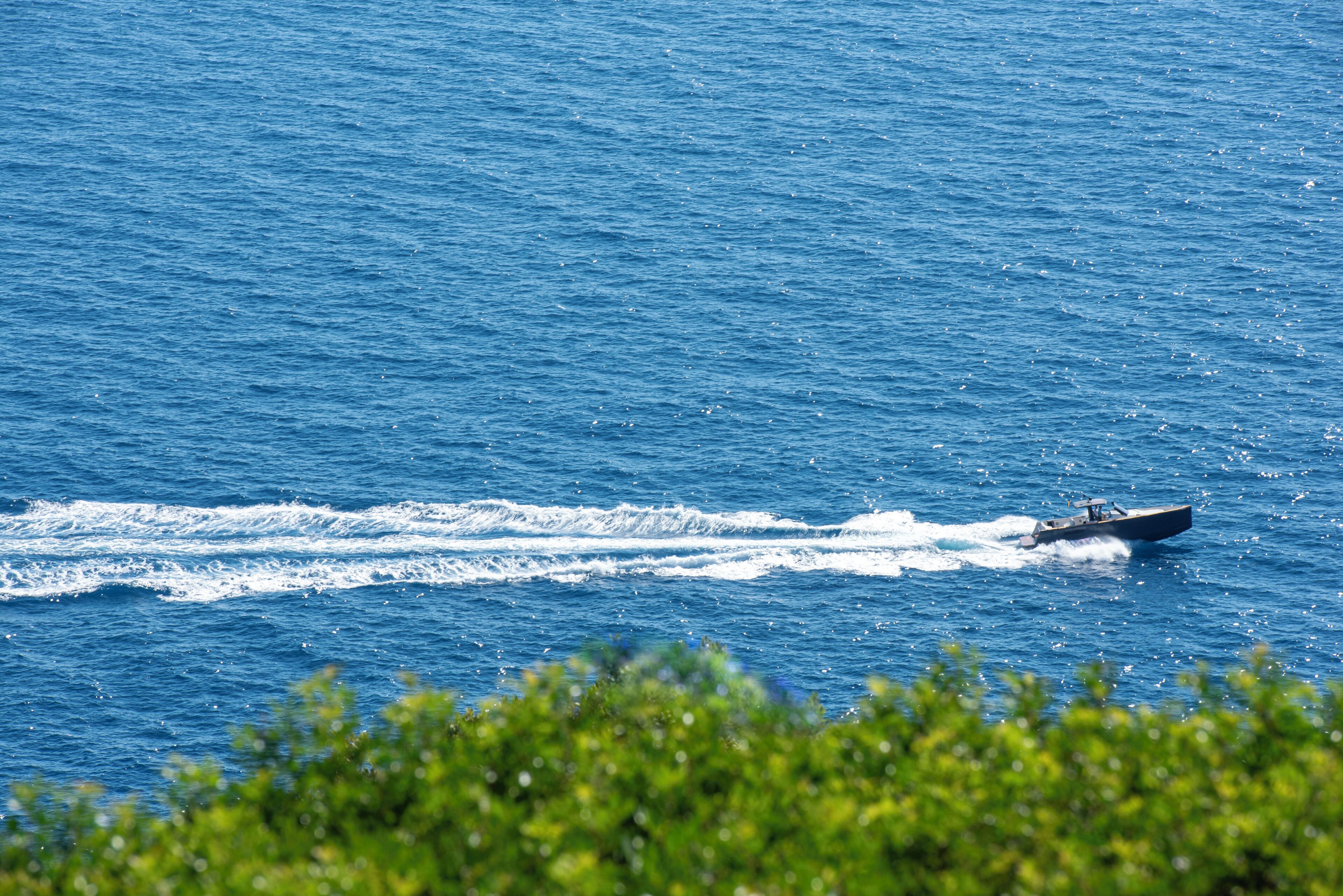 Un bateau naviguant sur une mer calme, avec une vue dégagée sur l’horizon.