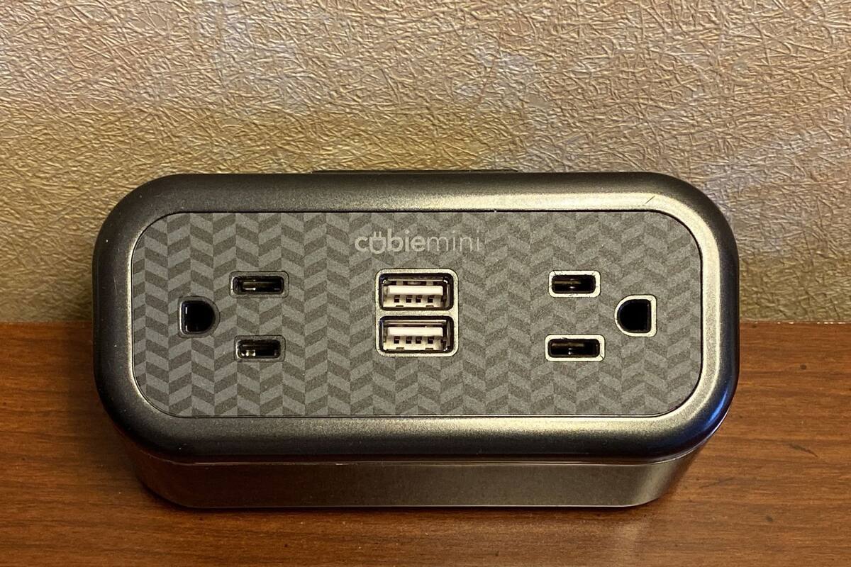 A portable device with a textured surface and multiple USB ports, placed on a wooden surface.