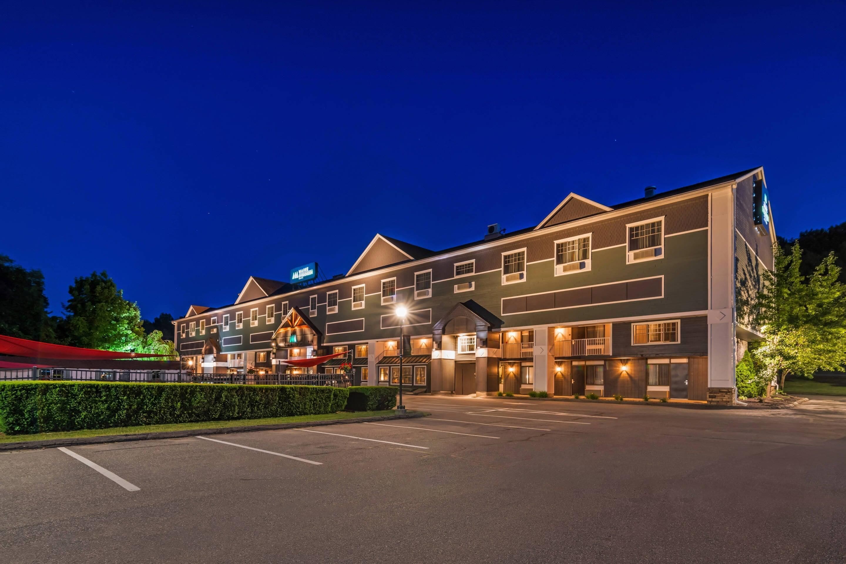 A multi-story hotel with a parking lot in front.