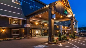 A hotel entrance with a covered walkway, outdoor seating, and a parking lot. - Maine Evergreen Hotel, an Ascend Collection Hotel (Augusta)