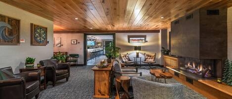 A cozy living room with leather sofas, a fireplace, and wooden ceiling.