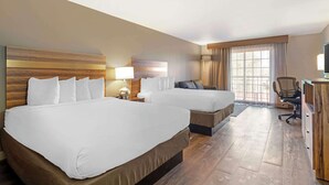 A hotel room with two beds, a desk, a chair, and a large window. - Best Western Cedar Inn & Suites (Angels Camp)