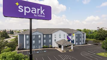 A hotel with a parking lot and a sign that reads 'spark by Hilton'.