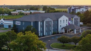 A multi-story hotel with a modern design, featuring a prominent 'Spark' sign, a covered entrance, and a parking area. - Spark by Hilton Indianapolis Northeast Fishers (Fishers)