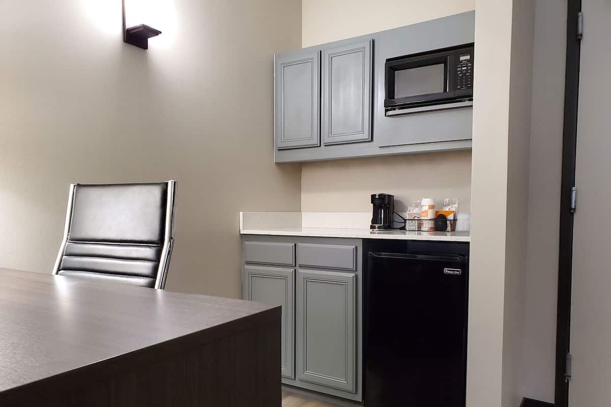 A modern kitchen with grey cabinets, a black dishwasher, and a microwave.
