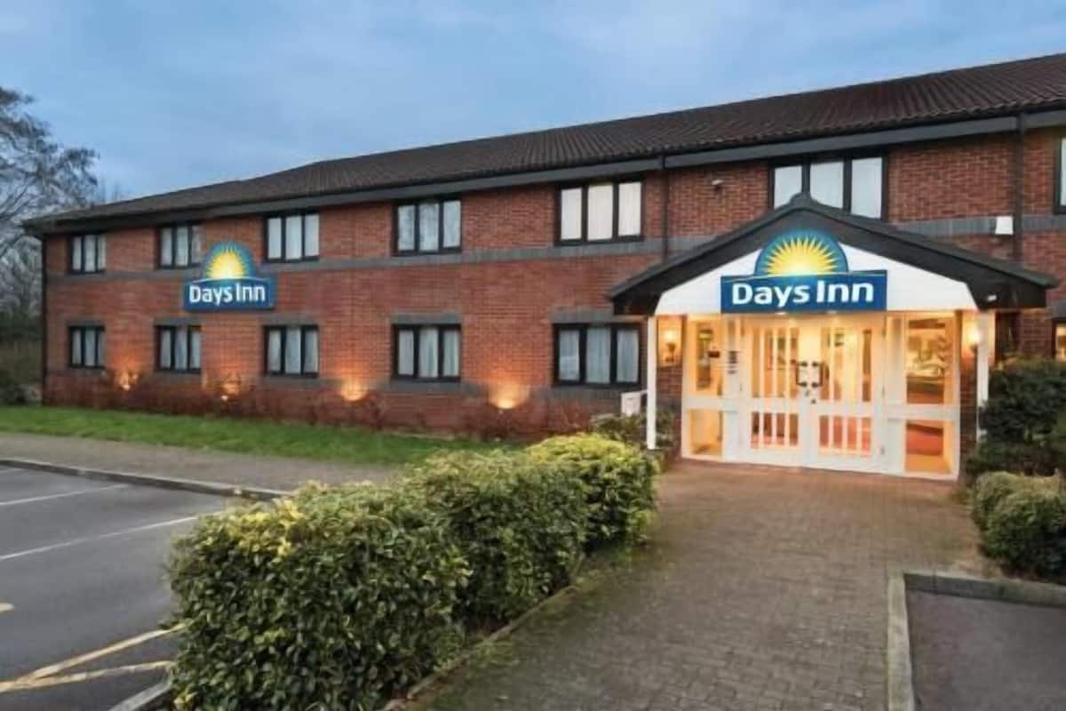 A Days Inn hotel with a brick facade, large windows, and a well-lit entrance.