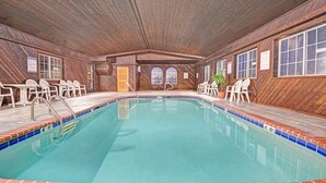 Una piscina interior con paredes de madera y suelo de baldosas.